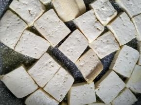 不粘锅内放入少许的食用油，小火加热放入豆腐块
