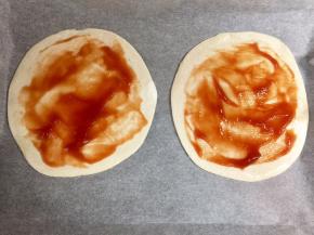 在飞饼皮上抹一层番茄酱，留出边缘不抹。