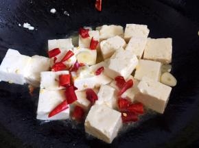 放入豆腐块和辣椒段轻轻翻炒几下
