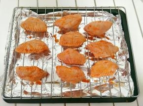 把腌好的鸡翅摆放在烤架上，预热烤箱