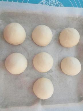 包好，封口朝下，原方中放在圆形纸托里的，我没有就只好直接放在烤盘里了，把烤盘放入烤箱，我的烤箱不带发酵功能，下面放大碗热水，热水和烤盘要有一定的空隙，进行二次发酵