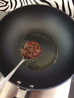 锅中放入油，烧热后，放入一勺的豆瓣酱。