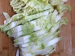 将白菜用水洗一下，切成段，放入料理机搅碎