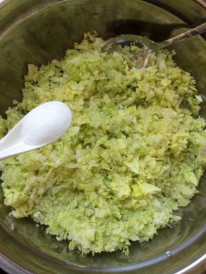 把搅碎的白菜中放入1小勺盐，腌制一小会，腌制出水后，攥干白菜，备用。