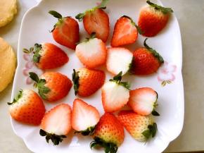 烤蛋糕的时间将草莓清洗干净，滤干水分，留蒂对半切开，留一部分切成碎丁