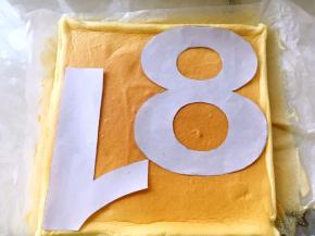 蛋糕片凉透后，将之前裁下的数字放在蛋糕片上，用小刀一点点刻出来