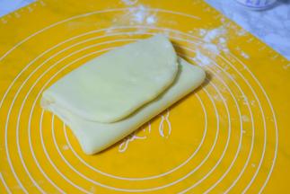 两边向中间叠一下，保鲜膜包好，再放冰箱冷藏15分钟，一共折叠三次，每次都要放冰箱冷藏15分钟再进行下一次折叠，第三次折叠完再冷藏15分钟