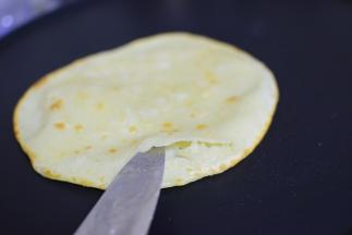 中火加热，加油，加饼，第一面稍微变色，翻面，鼓起来，用刀开一个口