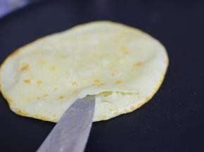 中火加热，加油，加饼，第一面稍微变色，翻面，鼓起来，用刀开一个口