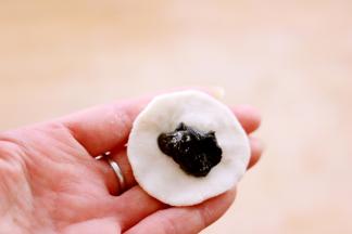 取白色面团按成圆饼后包入馅料