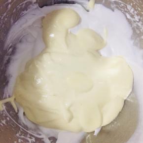 取一部分面糊和蛋白霜混合，筛入45克低粉，翻拌均匀后，再拌入剩余蛋白霜