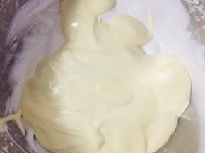 取一部分面糊和蛋白霜混合，筛入45克低粉，翻拌均匀后，再拌入剩余蛋白霜