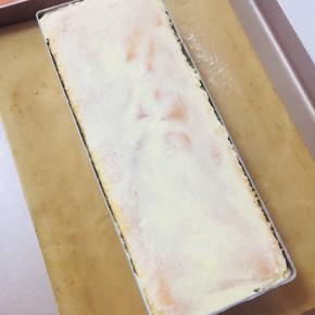 然后再挤入一层穆斯林奶油，最后加盖一片杏仁蛋糕片，压实，表面涂抹适当奶油，送入冰箱冷藏四小时以上，也可以进入速冻定型