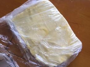 和面的时间，将黄油放入保鲜膜，擀成长方形薄片