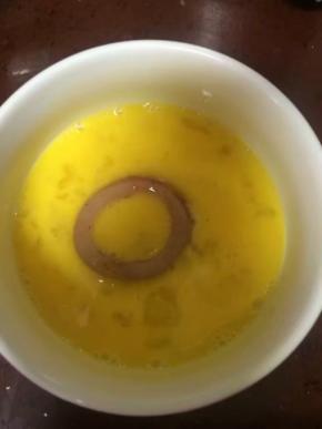 一个鸡蛋打散，腌制好的鱿鱼圈放入鸡蛋液中，裹上蛋液