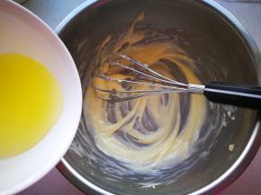 软化的黄油加入玉米油，搅拌至顺滑的状态，加入蛋清再次搅拌均匀。