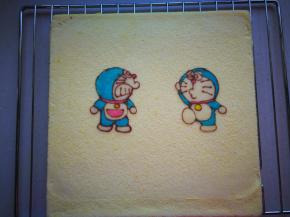 烤网上先铺一张油纸，将蛋糕倒扣，撕去表面的油布，表面虚盖一张油纸，防止表面干燥。