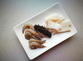 鱿鱼打十字花刀，即食海参提前拿出来解冻，鹰爪虾洗净后去虾线。