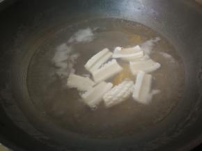 在煮面条的锅中将鱿鱼焯水，鱿鱼卷起来立马捞出。