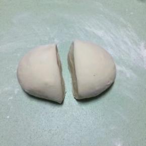 一切准备好之后，面团取出进行揉面排气，揉至光滑后分成两个剂子