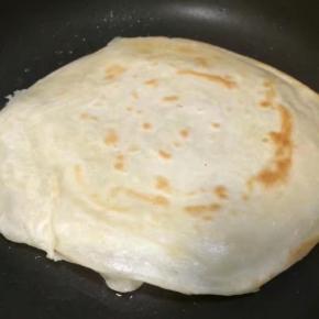 一面定型后再翻面继续慢煎，随着加热面饼中间就会慢慢的鼓起包