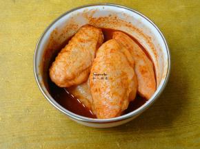 新奥良烤肉料加适量的清水拌均，放入鸡翅腌制30分钟；