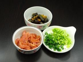 准备食材，瘦肉切薄皮，放油、盐、酱油、淀粉拌均，皮蛋切块，香葱切碎；