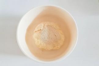 再稍微揉至没有干粉能成团，把酵母放在表面盖保鲜膜室温静置20分钟。（此步骤为面团自解过程）