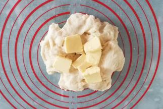 再加入软化的黄油，揉几分钟揉成光滑的面团；