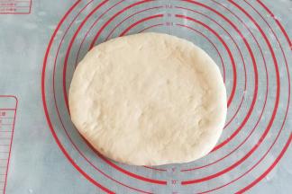 发酵好的面团取出挤压排气，然后擀开盖保鲜膜松弛10分钟左右；