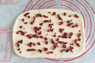 先刷上一层融化的黄油（或玉米油），再撒上适量蔓越莓干；