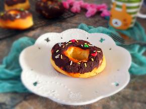 将甜甜圈表面蘸满巧克力酱，撒彩糖即可