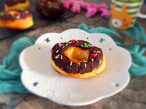 将甜甜圈表面蘸满巧克力酱，撒彩糖即可