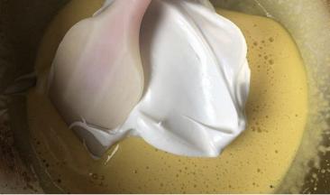 蛋白霜分两次加入蛋黄液中，用翻拌和切拌的手法搅拌均匀