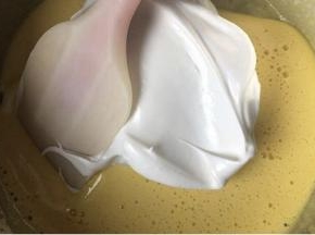 蛋白霜分两次加入蛋黄液中，用翻拌和切拌的手法搅拌均匀