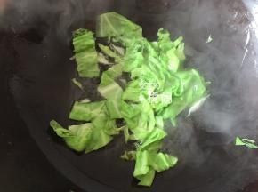 热锅冷油，倒入包心菜翻炒几下；