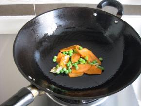 先放入胡萝卜片、青豆翻炒；