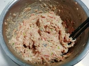 将拌均匀的馅料取一半出来放入另外一个盆中，顺着一个方向搅打上劲；