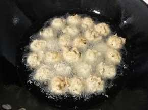 然后锅中倒入适量油，五成热时挤入肉丸中小火炸制，期间用漏勺多翻滚几次；