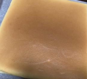 出炉后拎着油纸取出，上面盖一张油纸，翻面后取掉之前底部的油纸，在上面盖上新油纸再翻过来，如图，再盖上油纸放凉