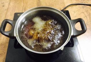 将半碗酱牛的汤和半碗水放到锅里加热至沸腾，制成汤头。