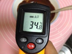待巧克力酱降温至35度左右，加入32克黄油