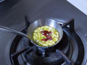 饭勺里放适量的橄榄油，放入蒜片，小火加热；待蒜片变成金黄色的时候，放入干红椒，榨出香味，离火