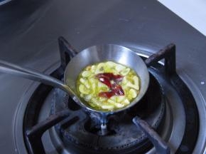 饭勺里放适量的橄榄油，放入蒜片，小火加热；待蒜片变成金黄色的时候，放入干红椒，榨出香味，离火