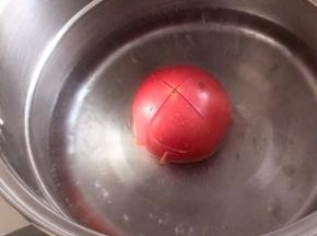 一个西红柿洗净，表面切十字刀，放入开水锅中烫一会