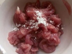 肉丝放碗里，放入一勺料酒、少许的干淀粉，抓拌均匀