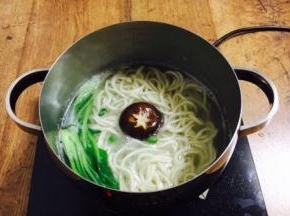 然后再次开火煮至沸腾，把豌豆、鲜香菇、小油菜依次放入锅里煮开。