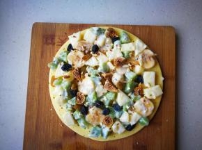 将水果酸奶摆放到松饼上，撒上水果干个杏仁碎。