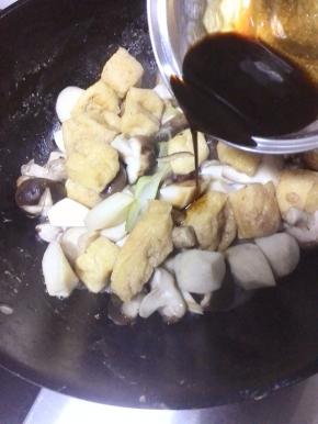 待双菇炒出水分时，倒入调料汁，加入适量的清水，大火烧开后，小火炖15分钟