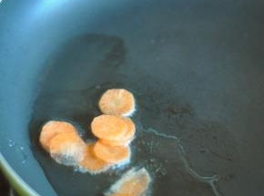 锅里留底油，放入胡萝卜片。